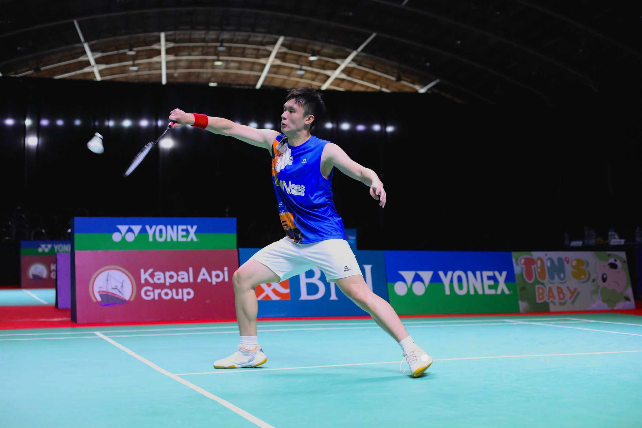 Sean Ngu reaching for a shuttle during a badminton match